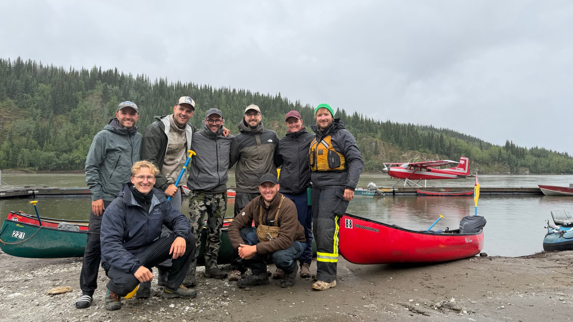 Expeditionsgruppe mit den Kanus am Flussufer in Kanada