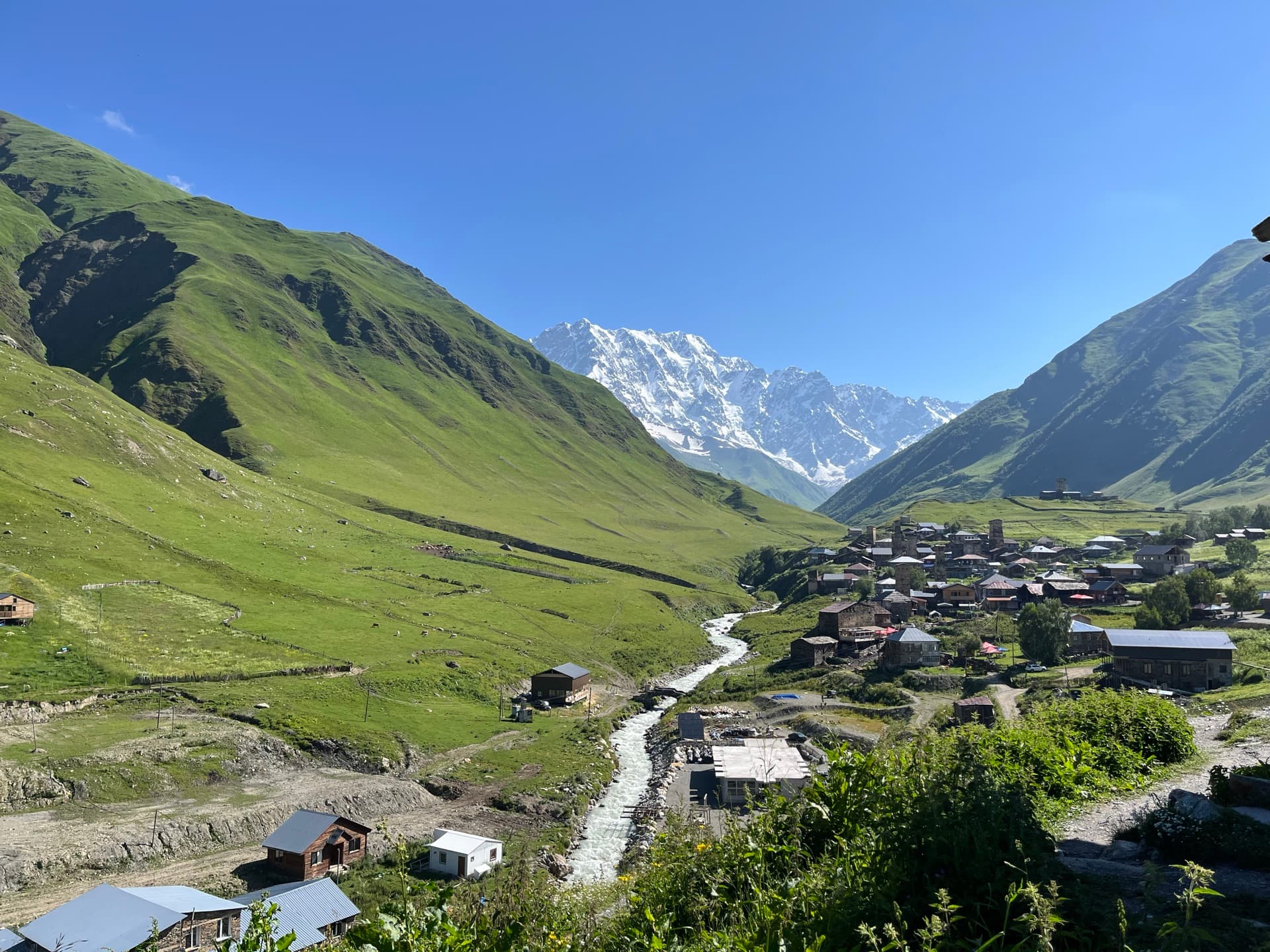 View across the green valley of Ushguli towards snow-covered Shkhara