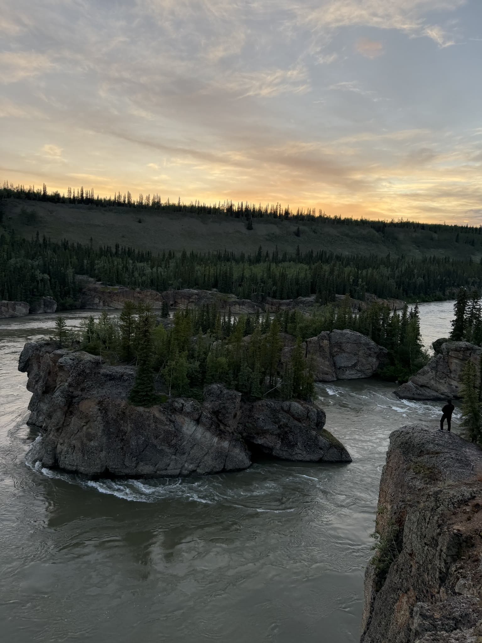 Teilnehmer blickt bei Dämmerung von einem Felsen auf die Five Finger Rapids