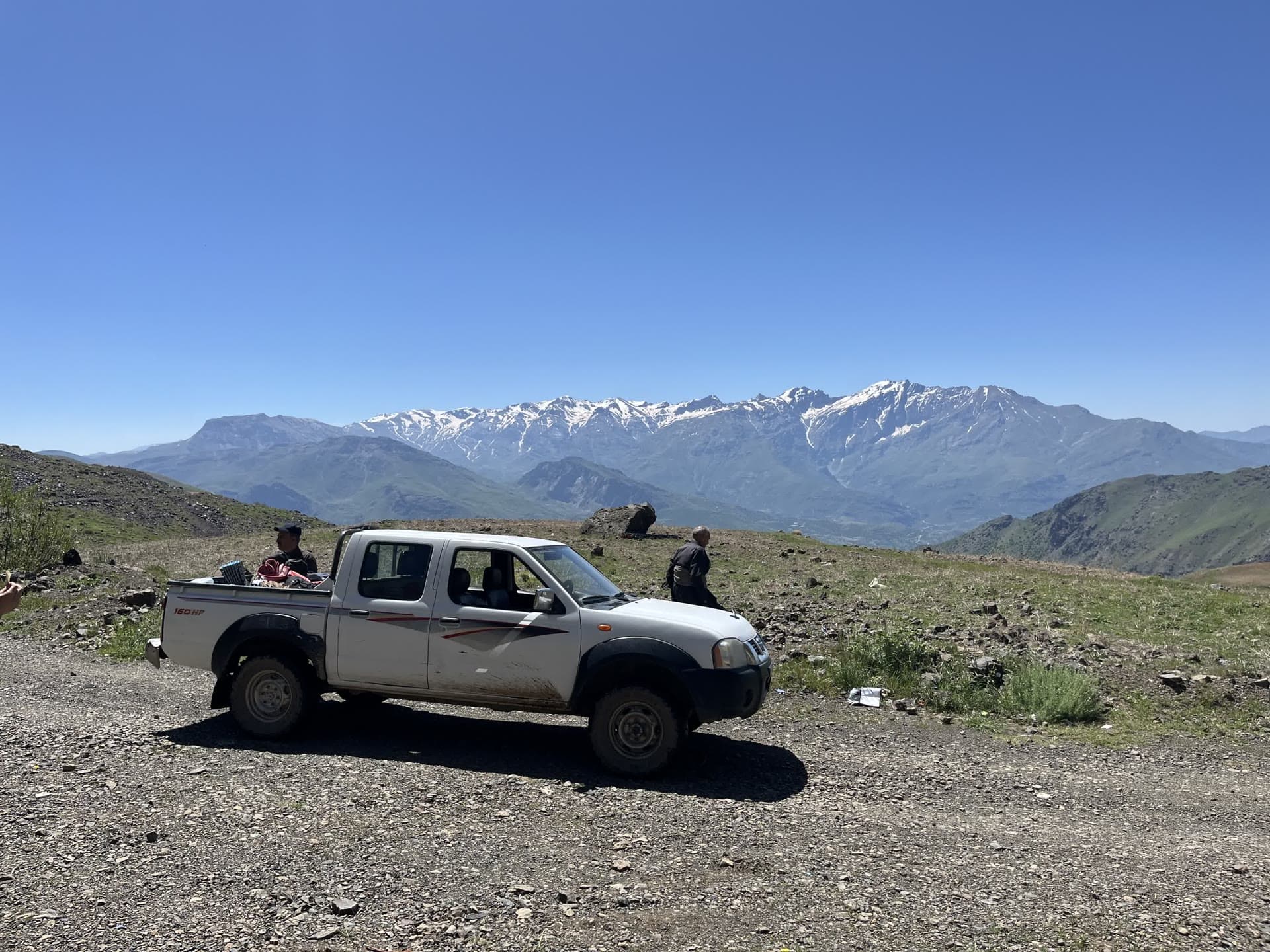 Geländewagen vor schneebedeckter Bergkette in Kurdistan
