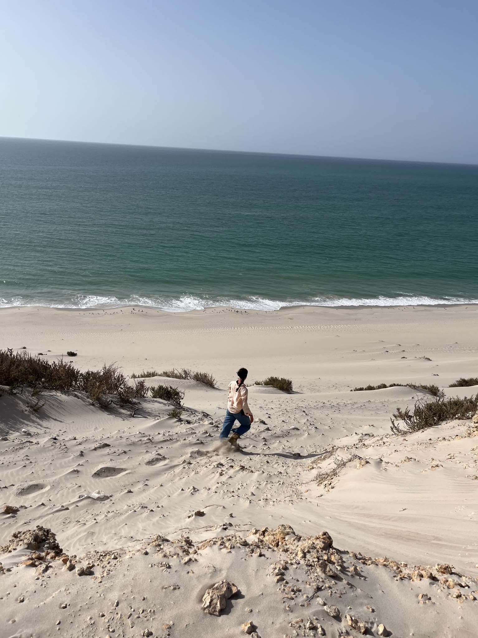 Teilnehmerin läuft eine Sanddüne hinab zur Atlantikküste